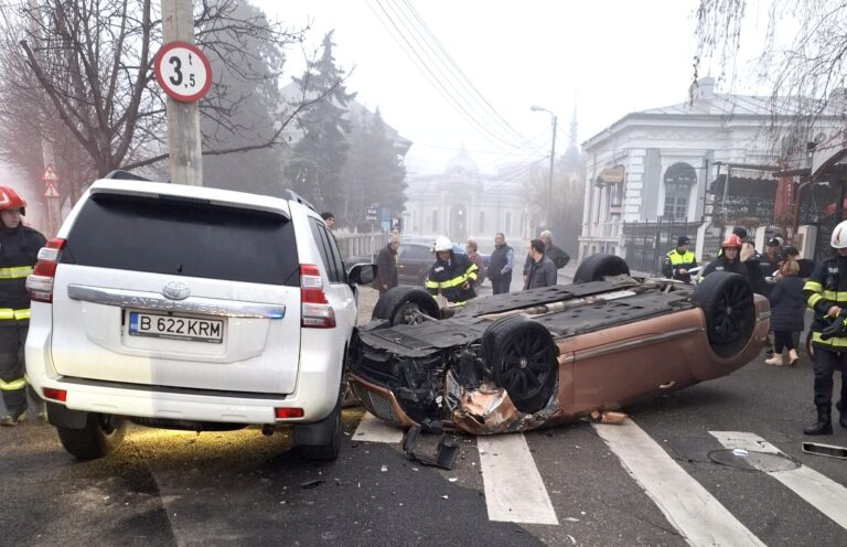 Accident grav într-o intersecție din Ploiești! Un autoturism a ajuns cu roțile în sus, după ce s-a izbit violent de o mașină parcată. Două persoane au fost rănite