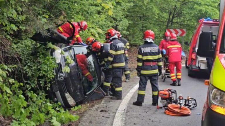 Au rămas încarcerați, dar au scăpat cu viață! Un șofer și o pasageră, momente dramatice după ce s-au răsturnat cu mașina într-o curbă periculoasă