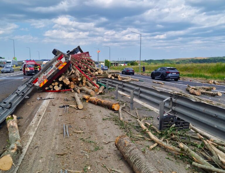 A distrus glisiera mediană și a îngreunat traficul rutier pe A1! Un autotren plin cu lemne s-a răsturnat. În accident a fost implicat și un autoturism