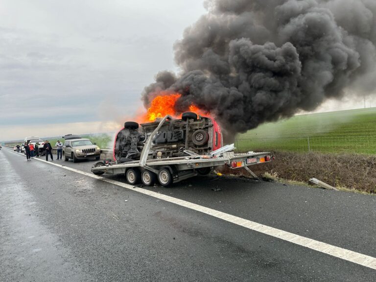 Panică pe autostradă! O ambulanță de dializă, răsturnată pe o platformă, cuprinsă de flăcări