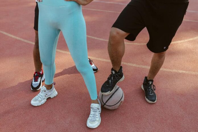 trei persoane imbracate in echipament sportiv pe un teren cu o minge
